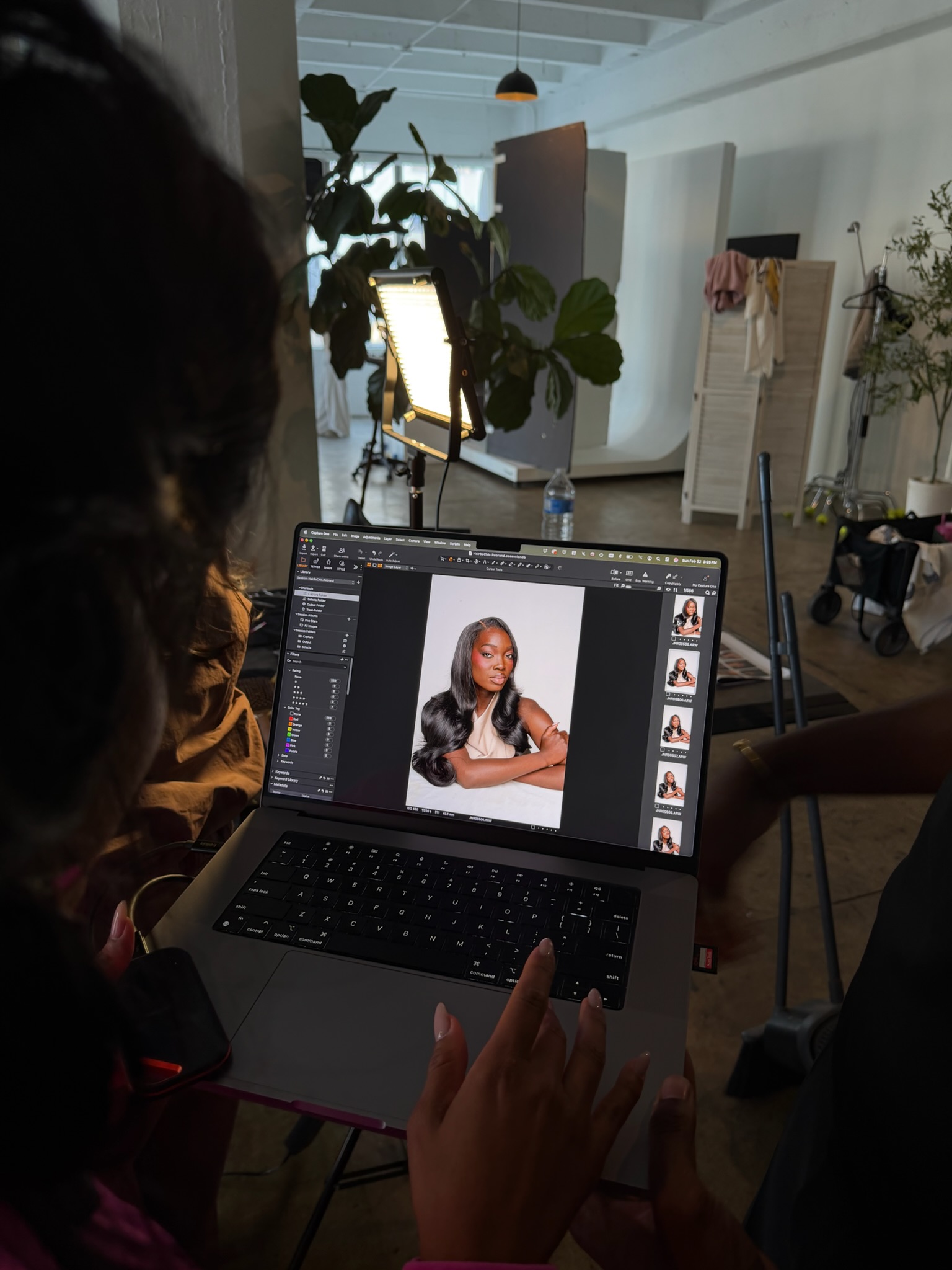 Behind the scenes of a photoshoot, with a portrait displayed on a laptop in the studio.
